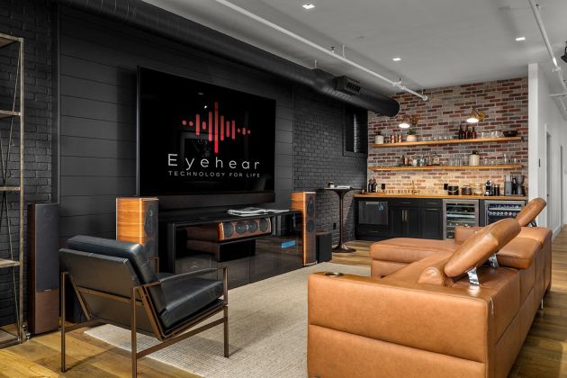 Eyehear Showroom living room with TV, speakers and suede furniture