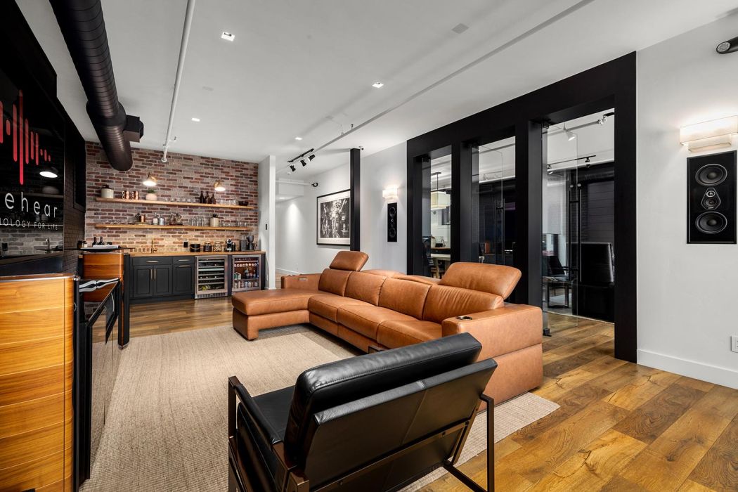 Eyehear Showroom living room with TV, speakers and suede furniture