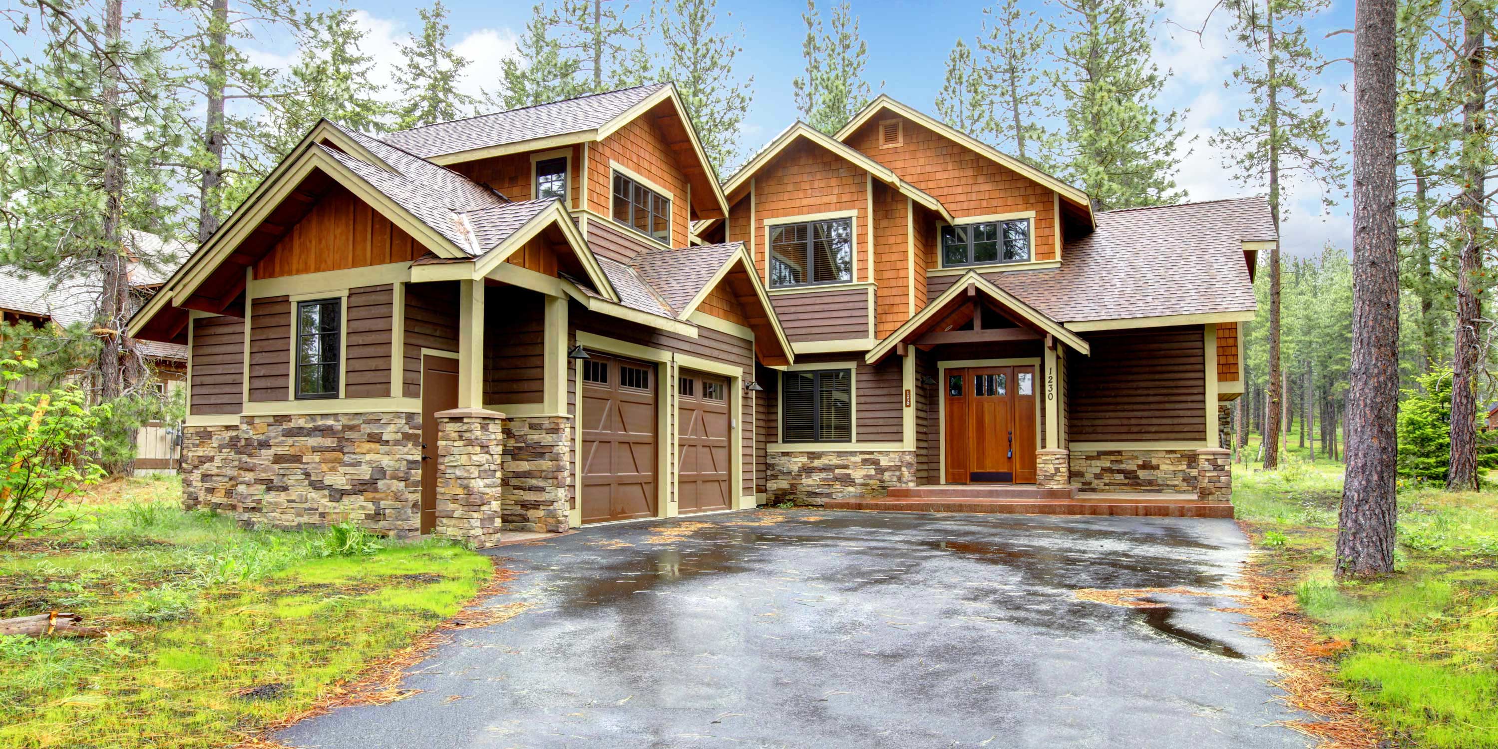 large home with wooden siding and brick, cabin style home