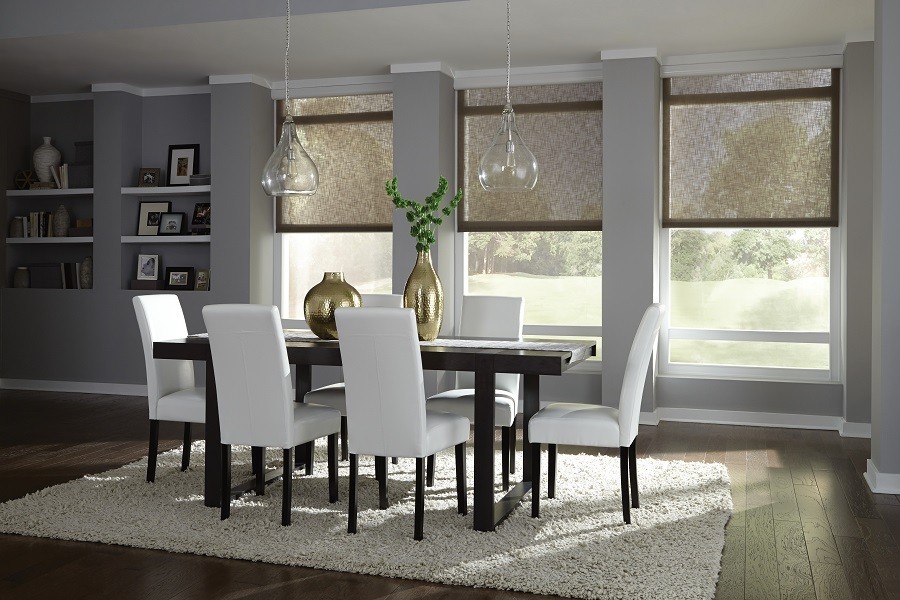 Sophisticated open concept dining room with sunlight streaming through fashionable motorized shades.