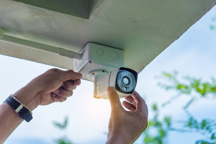 A home technology expert installing a video surveillance camera.