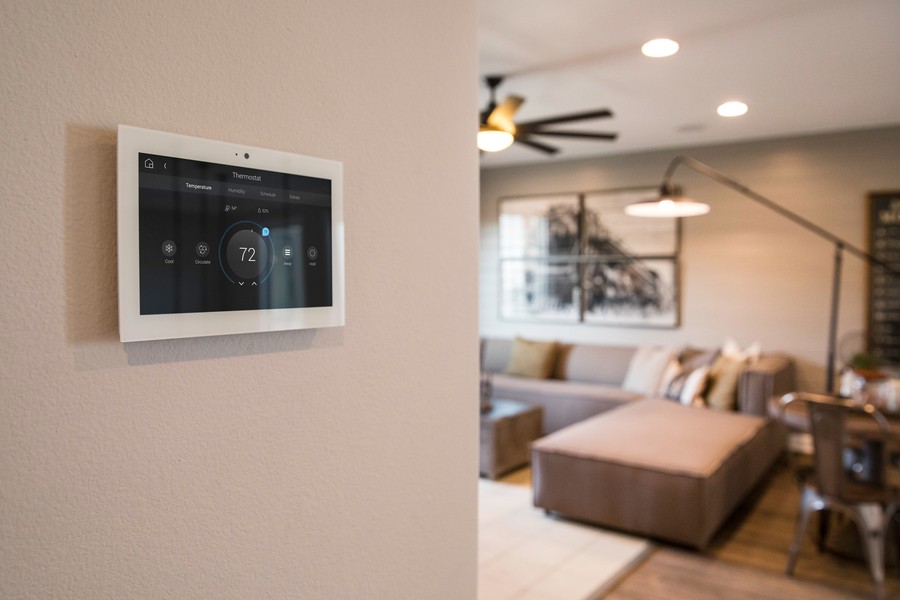a Control4 touch panel mounted on the wall of a living room.