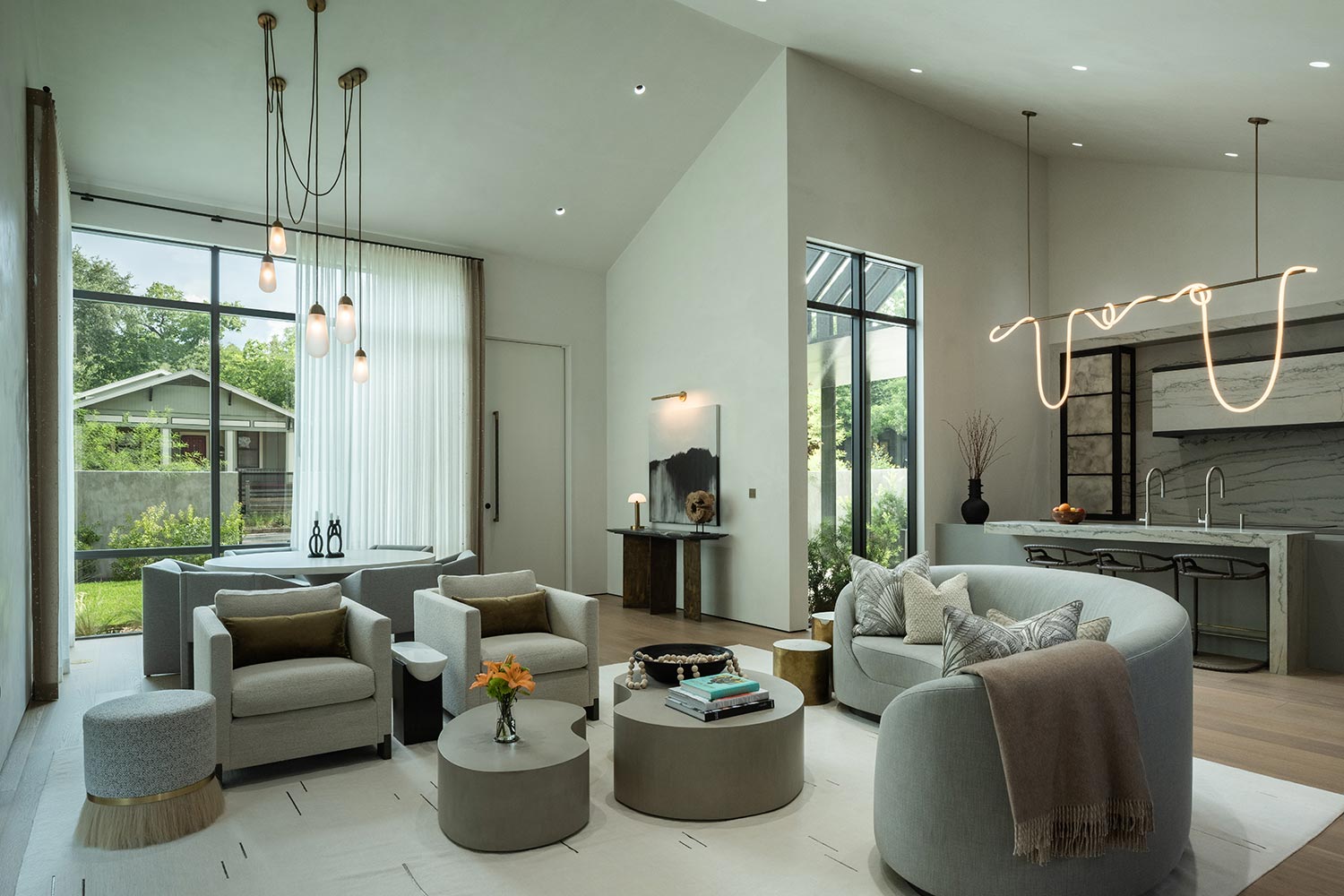 Modern open living room flooded with bright natural daylight from large windows