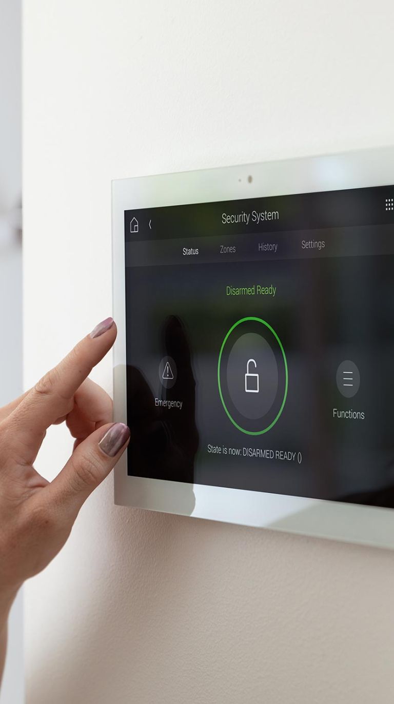 Hand using wall-mounted smart home security control panel