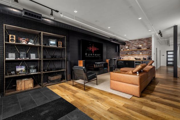 Eyehear Showroom living room with TV, speakers and suede furniture
