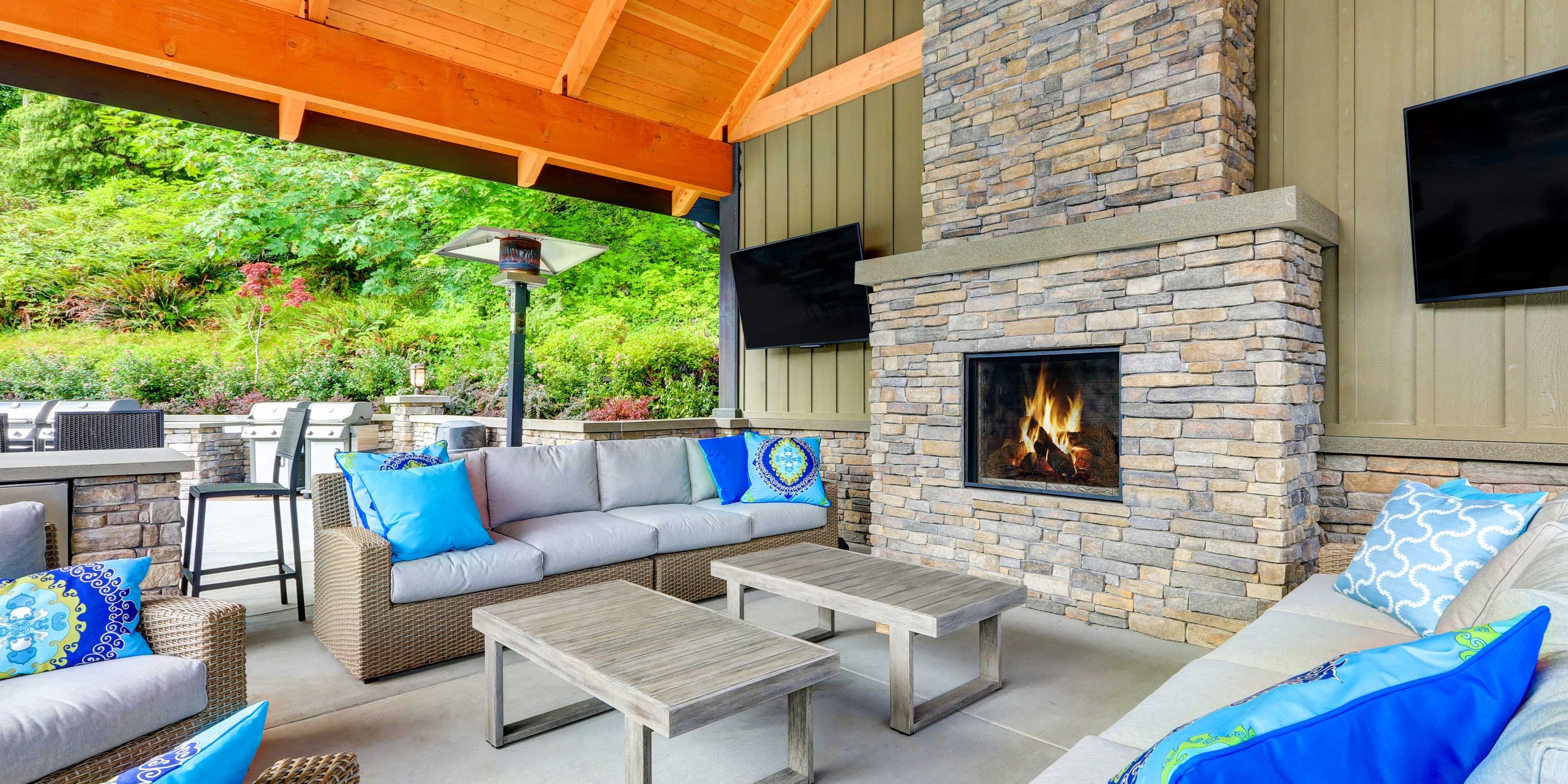 outdoor patio area with blue pillows on a grey couch
