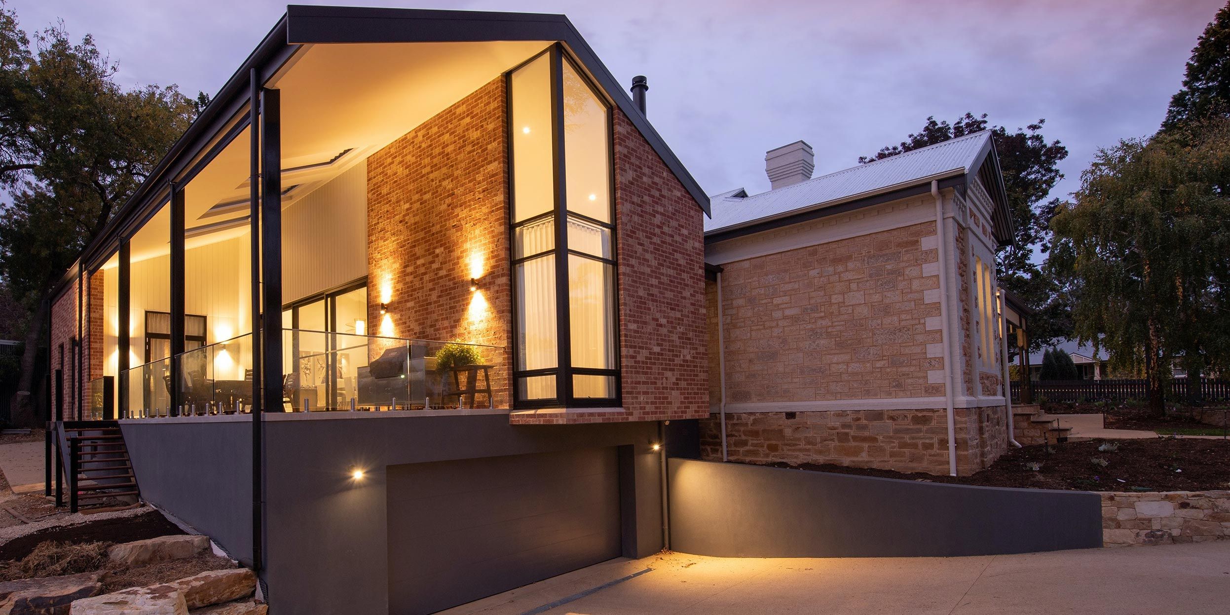 home in the woods with grey siding and brick walls